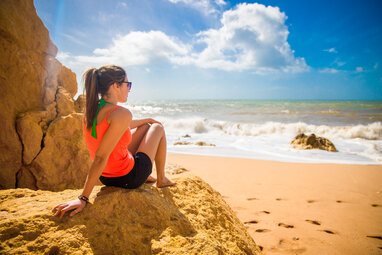 Girl sitting on rock at beach